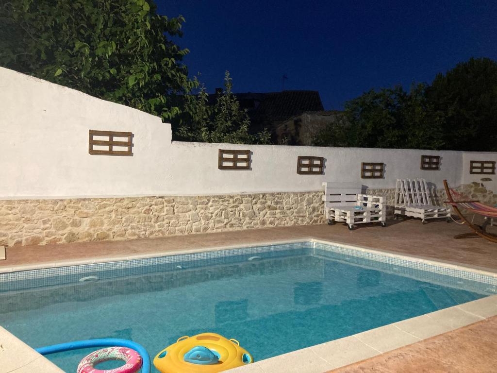 a swimming pool in a yard with two chairs at El Páramo in Castronuevo de Esgueva