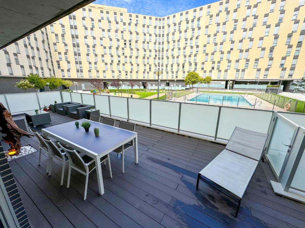 un balcone con tavolo e sedie e un edificio di El Olivo del Pilar Turistea a Saragozza