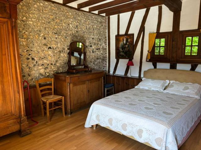 une chambre avec un lit, une coiffeuse et un miroir dans l'établissement Les Côtières, à Maresville