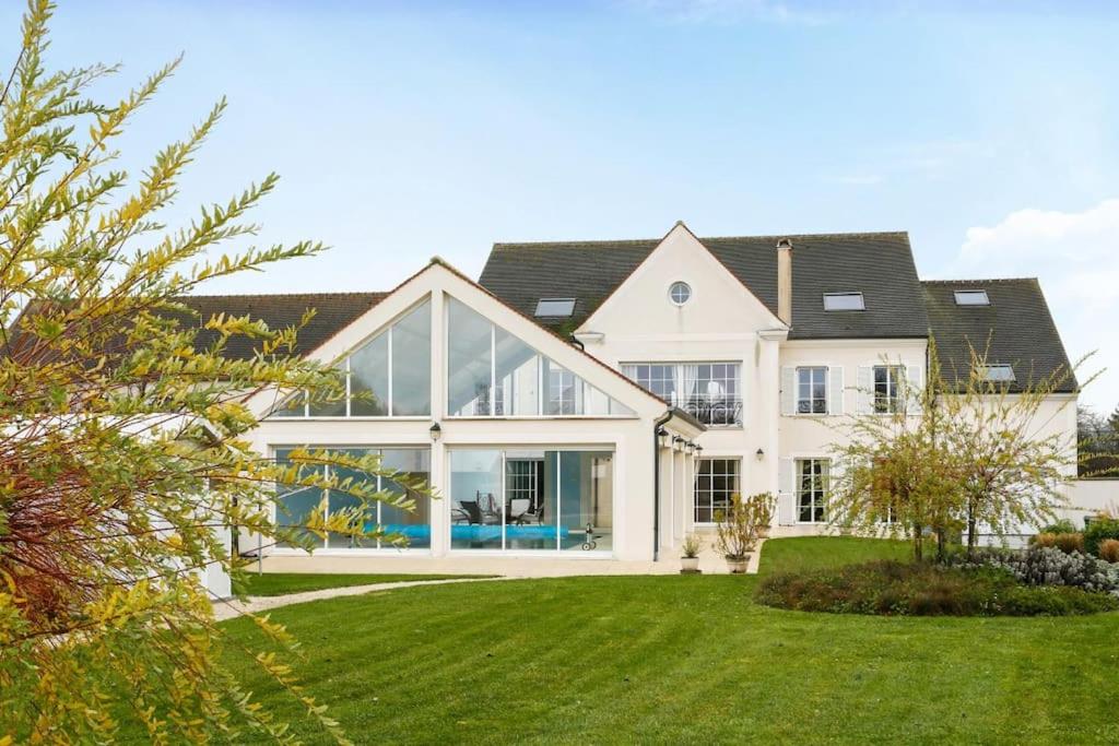 Cette grande maison blanche dispose de grandes fenêtres et d'une cour. dans l'établissement Disneyland Paris Maison de prestige, à Villeneuve-le-Comte