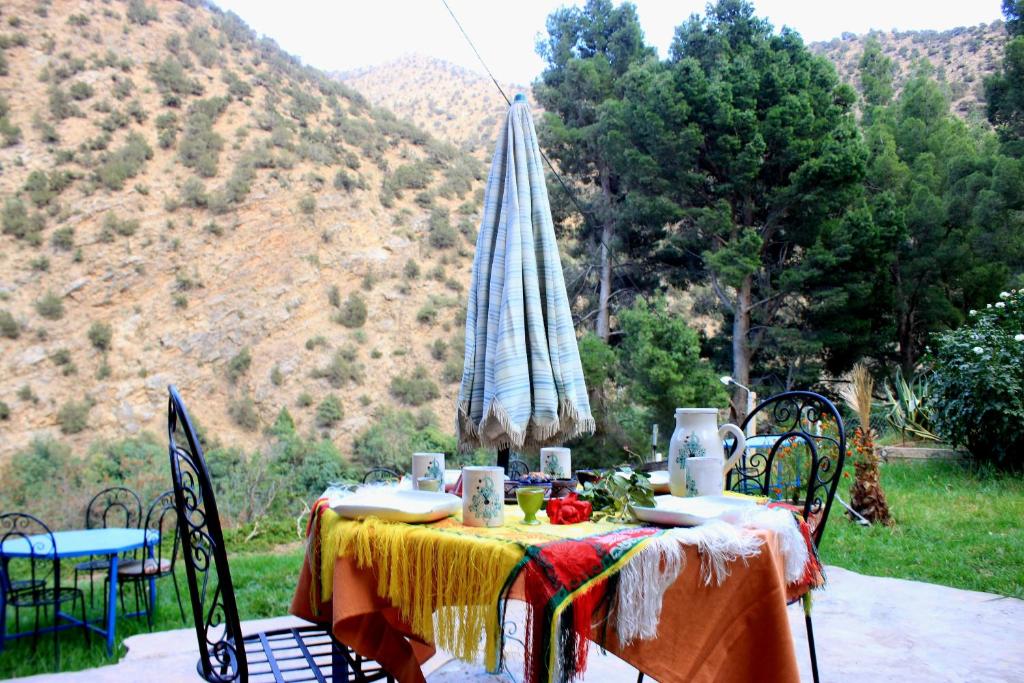 a table with a table cloth on it with mountains in the background at Atlas Tigmi in Ourika