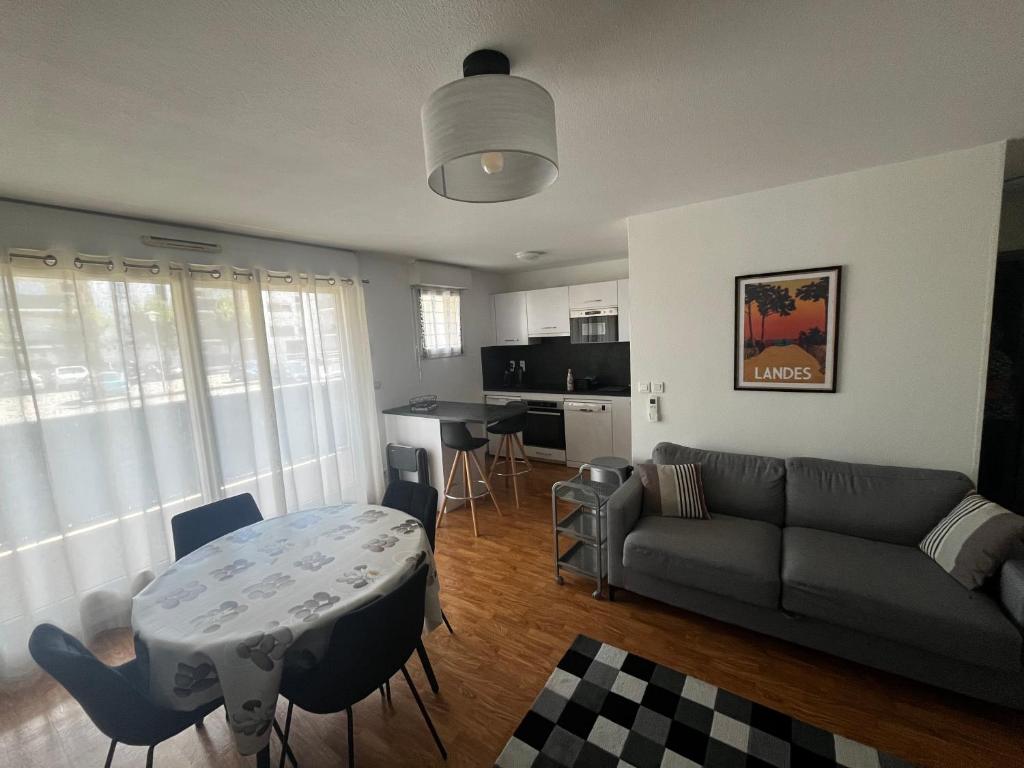 un salon avec un canapé et une table dans l'établissement Les Balcons du Soleil - idéal Curistes - classé 3 étoiles, à Saint-Paul-lès-Dax