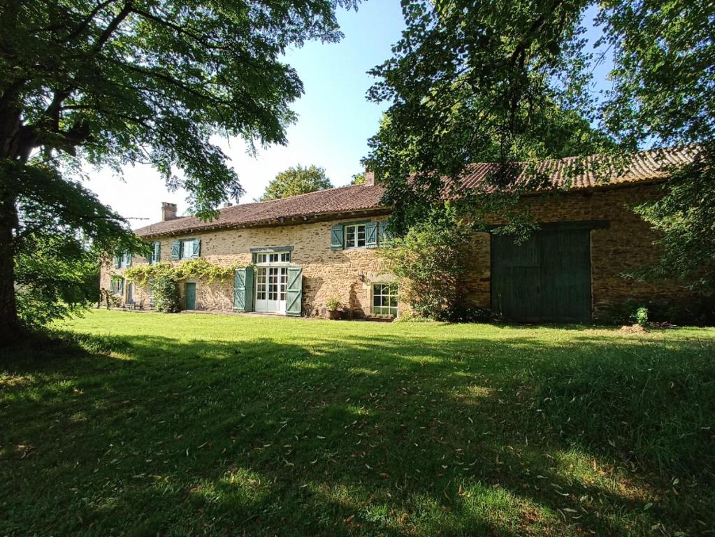 une ancienne maison en briques avec une grande cour dans l'établissement Le Bonheur du Périgord - Gîte, à Mialet