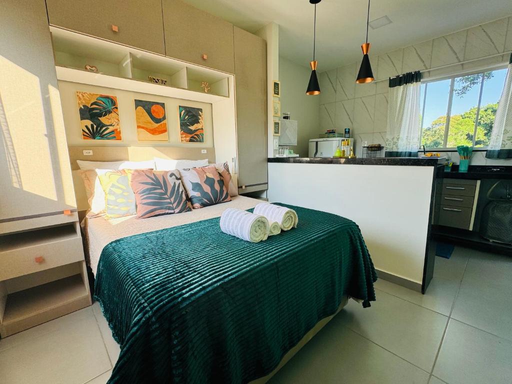 a bedroom with a bed with two towels on it at Stúdio equipado em Xerém - St 7 in Xerém