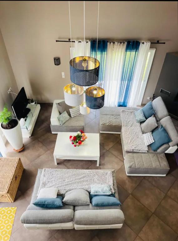 un salon avec des canapés et un lustre dans l'établissement Maison des Grézels, à Saint-Cybranet