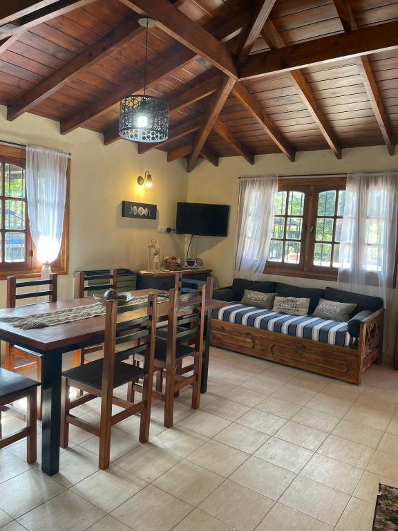 a living room with a couch and a table and chairs at la Casita del bosque in Villa Gesell