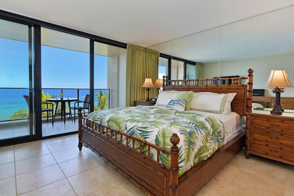 a bedroom with a bed with a view of the ocean at Mahana 813 in Kahana