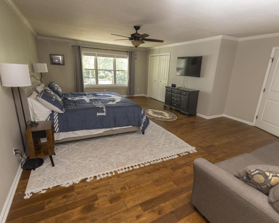 un dormitorio con una cama y un sofá en Mark and Faiths Lake House, en Worthville