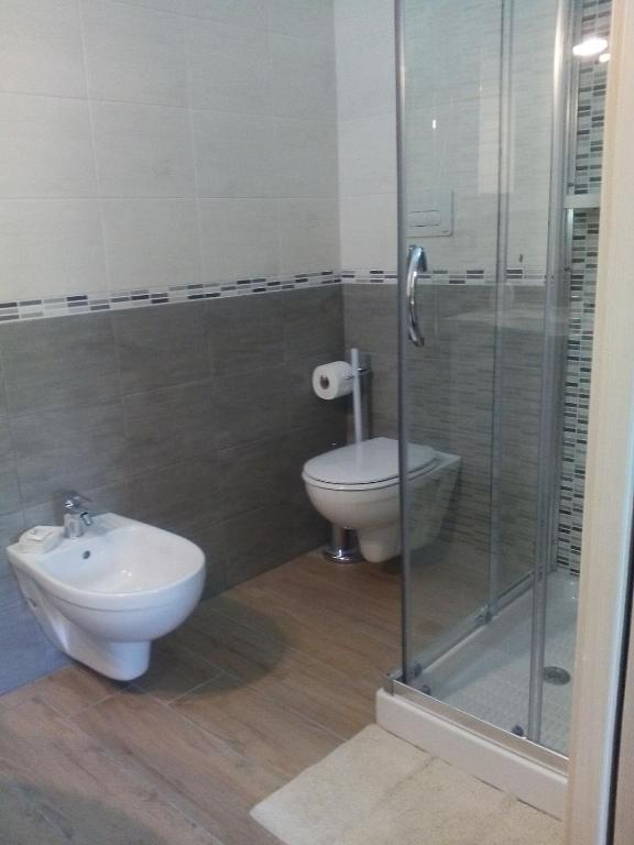 a bathroom with a toilet and a glass shower at B & B La Magnolia in Specchiolla