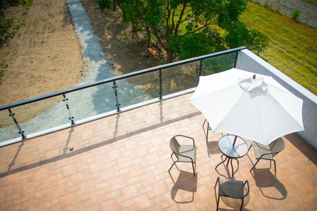 a white umbrella and two chairs and a table with an umbrella at Hai Yue Wan Resort Club in Shunan