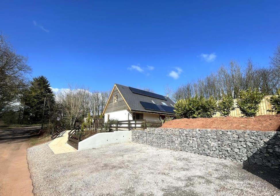 a house with a stone wall in front of a house at Stunning cottage with hot tub in Marldon