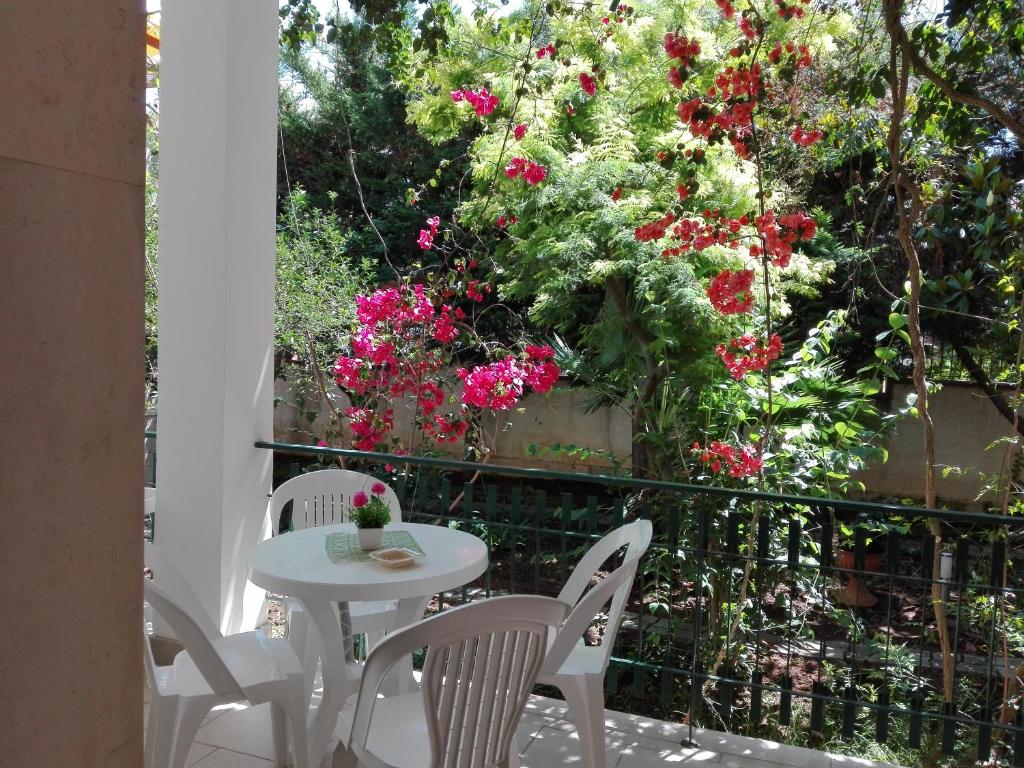 a table and chairs on a balcony with flowers at B & B La Magnolia in Specchiolla