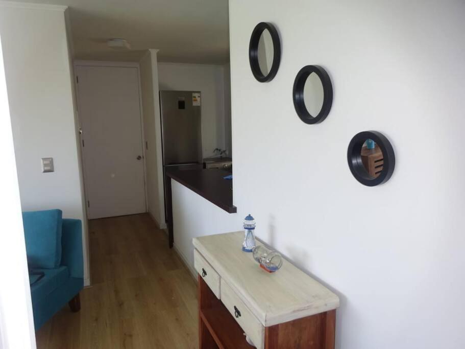 a living room with a blue chair and a white wall at Lomas de Papudo 4 in Agua Salada