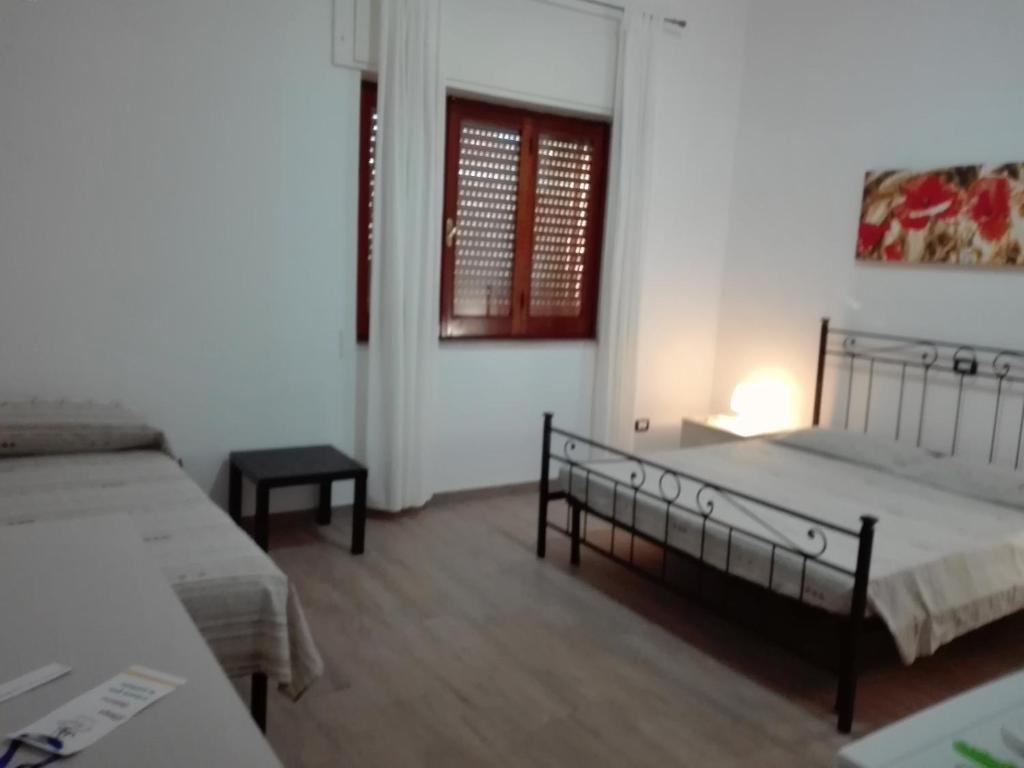 a bedroom with two beds and a table and a window at B & B La Magnolia in Specchiolla