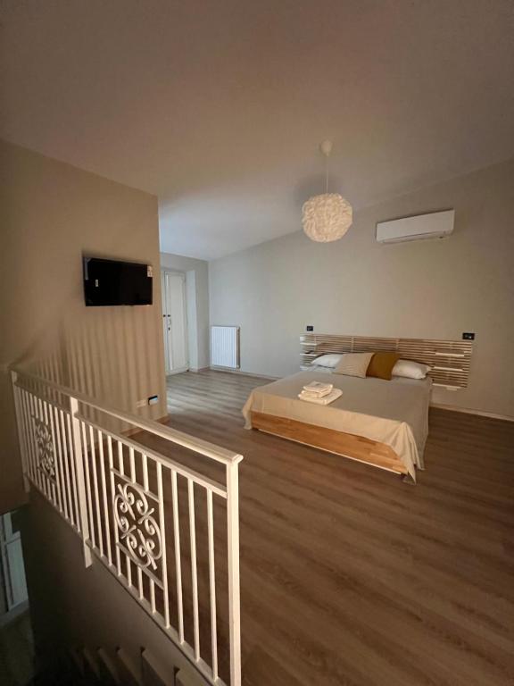 a bedroom with a bed and a balcony with a television at Cataleya comfort room in Aiello del Sabato