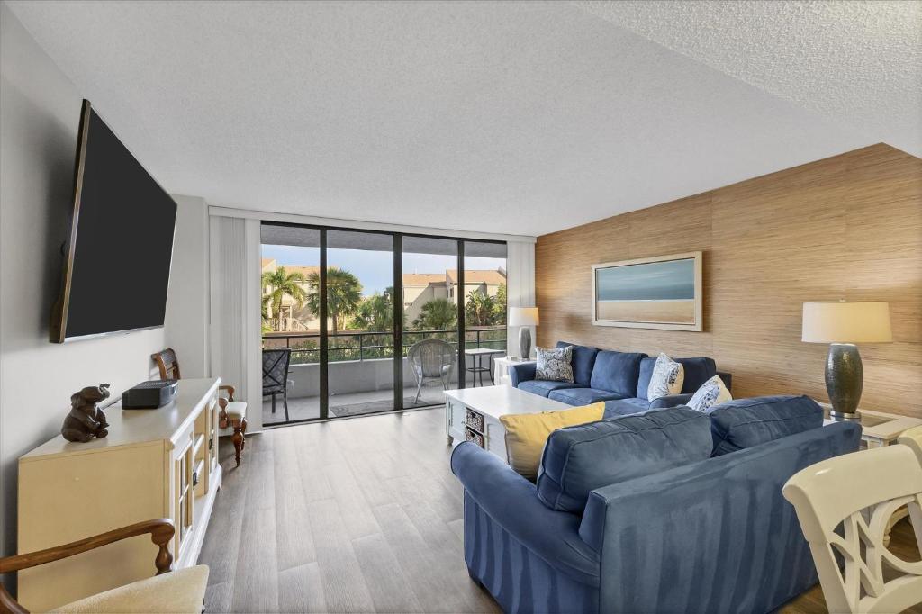 a living room with a blue couch and a table at 6415 Midnight Pass #202 in Siesta Key