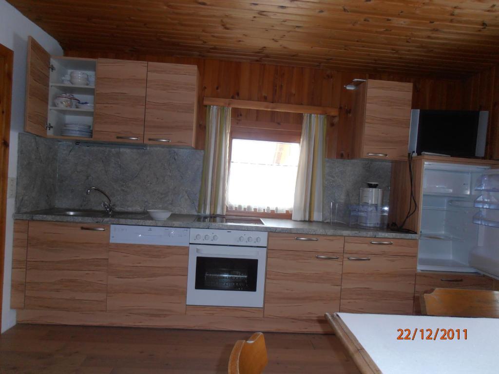 a kitchen with wooden cabinets and a stove top oven at Huberbauer in Johnsbach