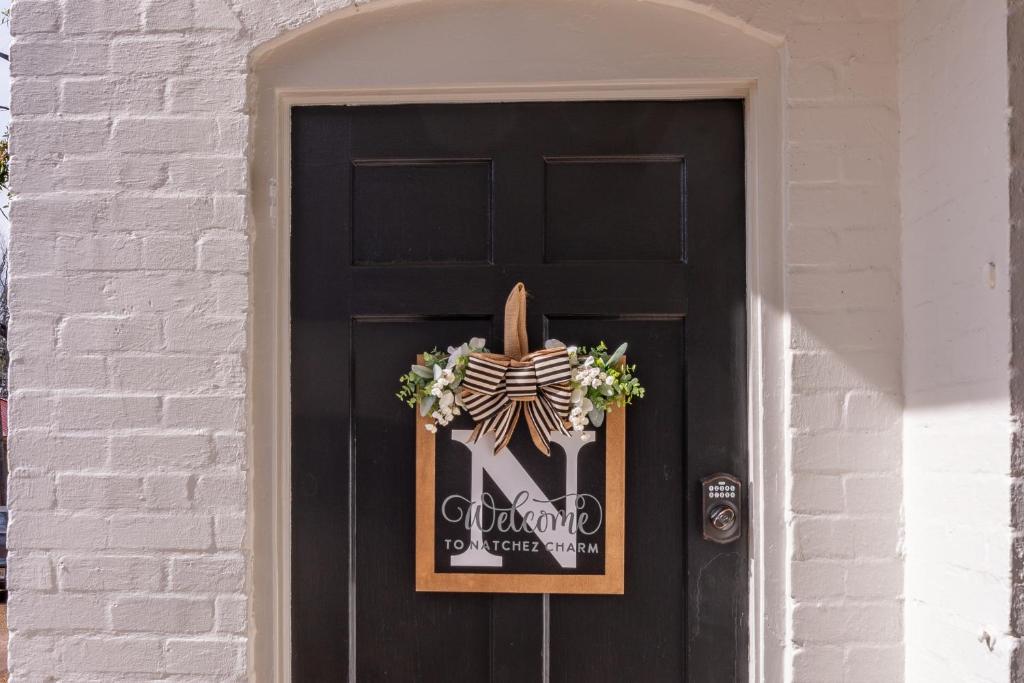 a black door with a skeleton sign on it at Natchez Charm - Studio, 1 Bath, Full Kitchen, King Bed, 2 Blocks from Mississippi River in Natchez