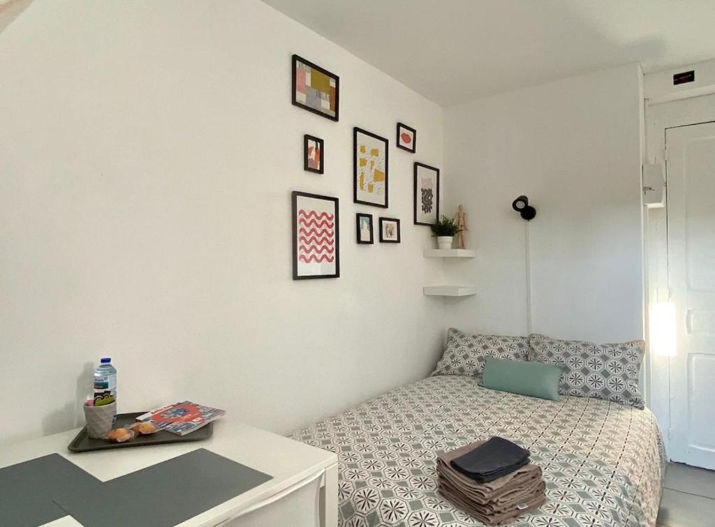 une petite chambre avec un lit et une table dans l'établissement Studio Rue Saint Jean, à Caen