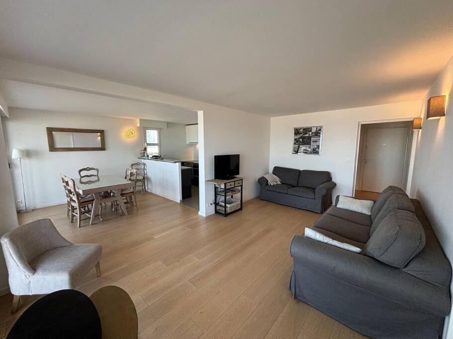 un salon avec un canapé et une table dans l'établissement L Océan à vos Pieds Résidence Ouragan, à Le Touquet-Paris-Plage