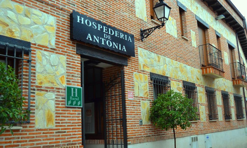 a sign on the side of a brick building at Hospedería de Antonia in Ajalvir