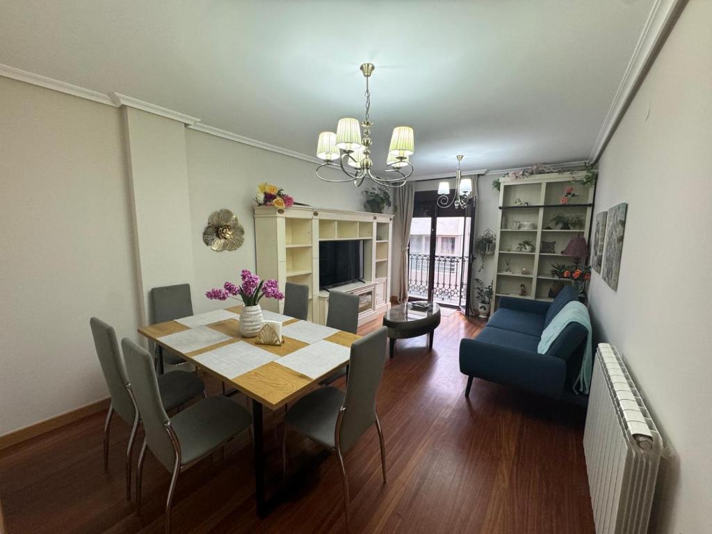 a dining room with a table and a blue couch at Avanza 4 Plaza Galicia in Sarria