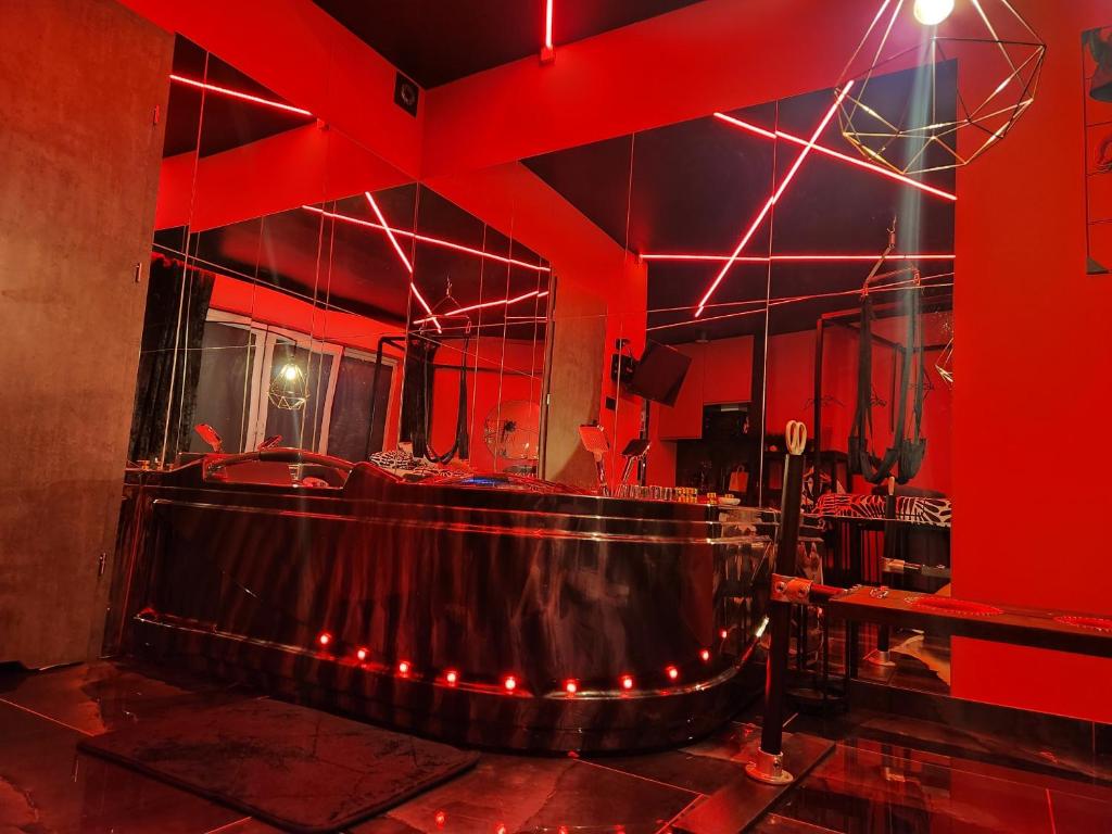 ein rotes Zimmer mit einer Badewanne in der Mitte in der Unterkunft NEW in GDAŃSK! RED ROOM in the HEART of GDAŃSK - BDSM - with a luxury JACUZZI and access to a sauna in Danzig