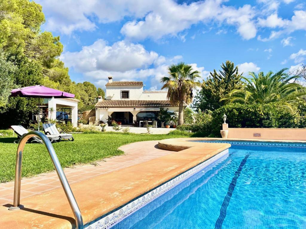 a swimming pool in front of a house at Casa rural exclusiva con vista al mar en Calpe in Empedrola