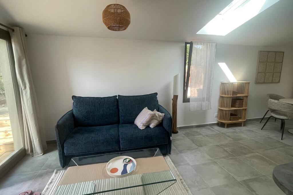 un salon avec un canapé bleu et une table dans l'établissement Sérénité Raphaëloise, à Valescure