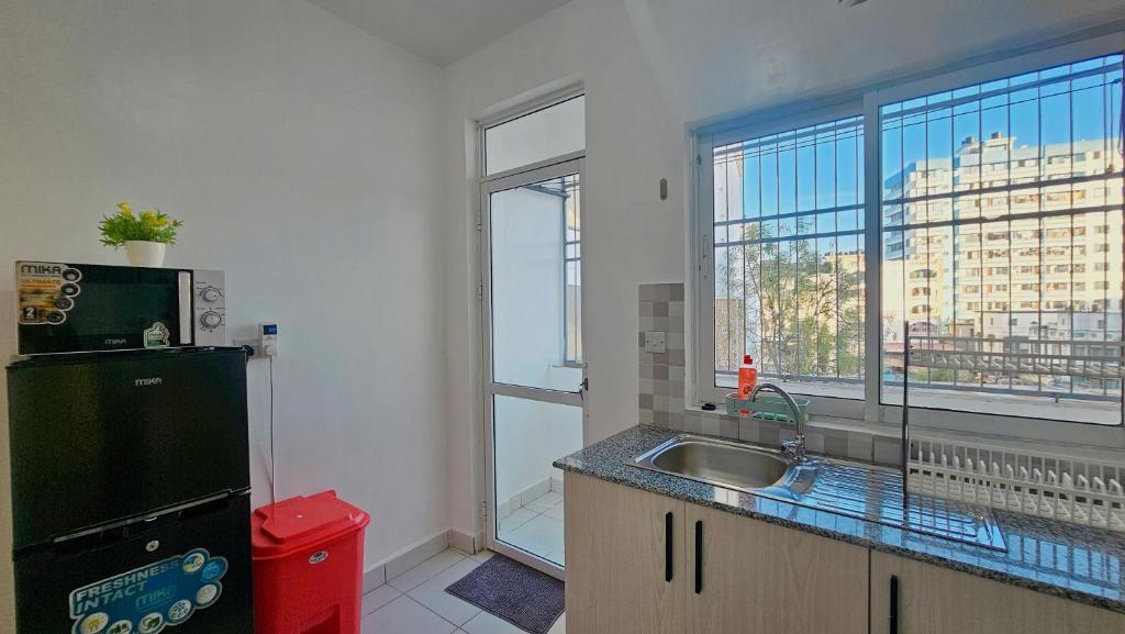 a kitchen with a sink and a large window at 3 bedroom mombasa CBD with AC in Mombasa