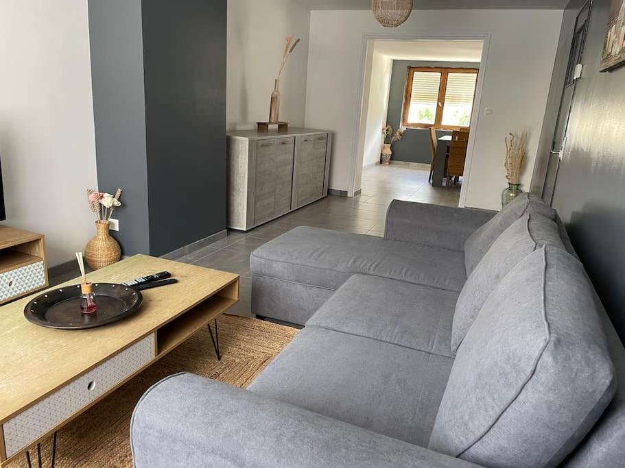 a living room with a couch and a table at Escapade Cambresienne in Cambrai