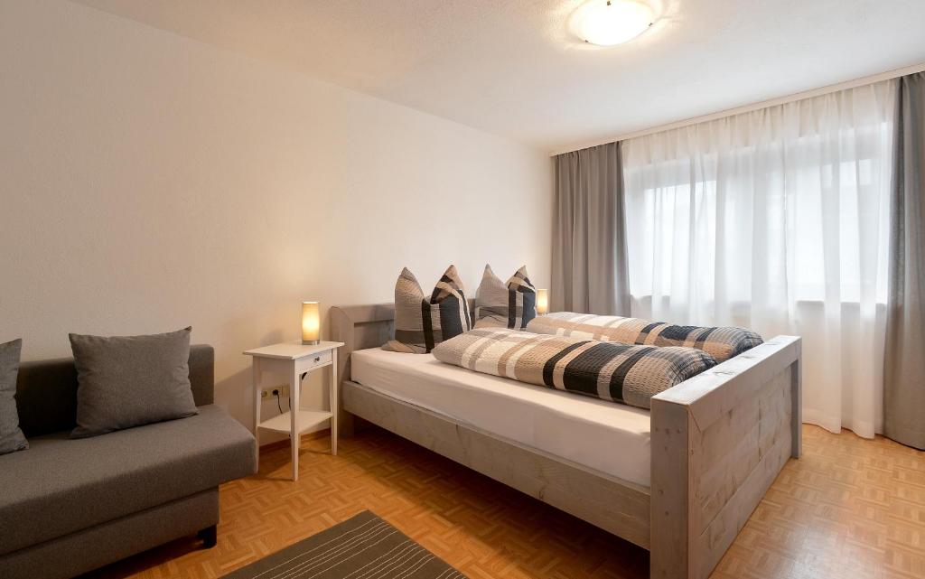 sypialnia z łóżkiem, kanapą i oknem w obiekcie Ferienwohnungen Wies w mieście Söll