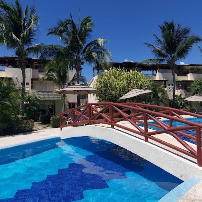 a swimming pool with a wooden bridge next to a building at Villa Sol Terrasol Acapulco Diamante in Acapulco