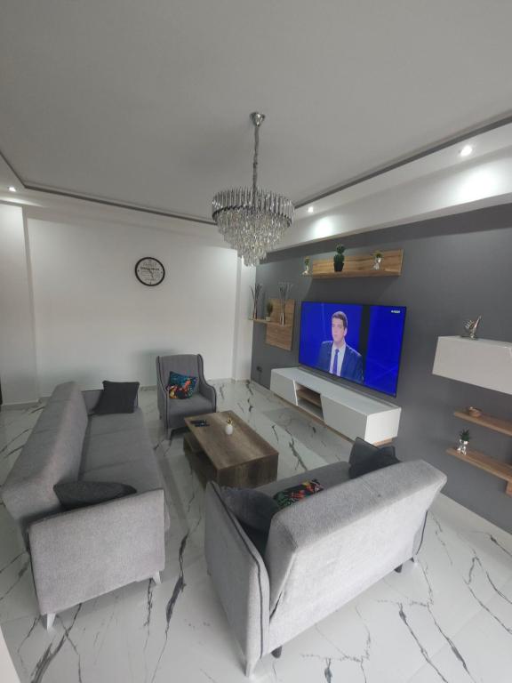 een woonkamer met banken en een flatscreen-tv bij Appartement DreamLand in Marrakesh