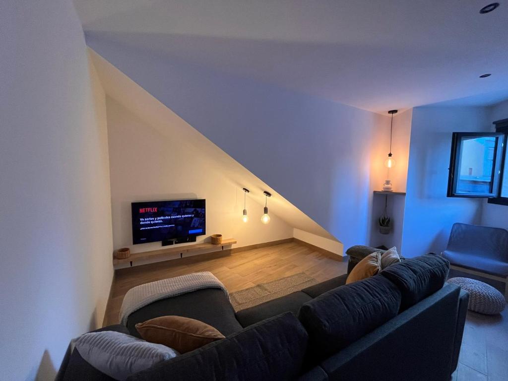 a living room with a couch and a tv at Apartamento Peña in Sardina