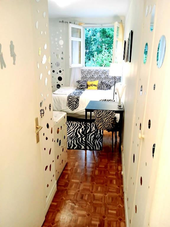 une petite chambre avec un lit et une fenêtre dans l'établissement Appartement entier à Neuilly-sur-Seine, à Neuilly-sur-Seine