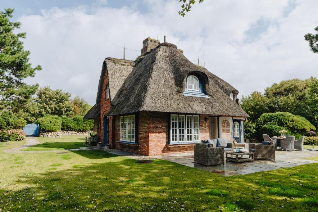 ein kleines Haus mit Strohdach auf einer Wiese in der Unterkunft Watt Perle in Kampen