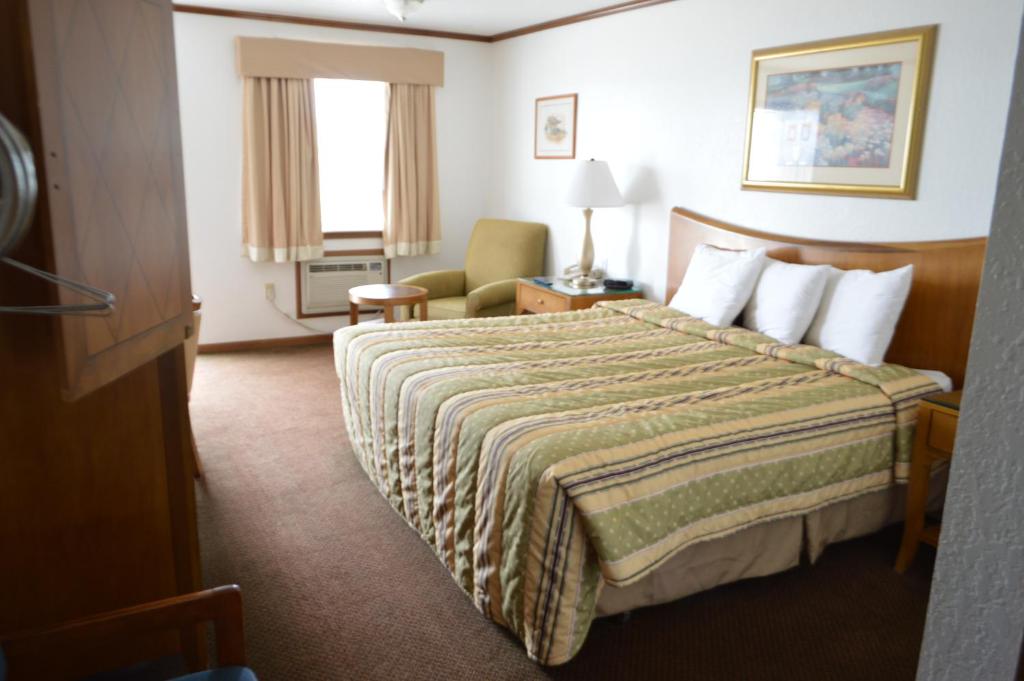a hotel room with a bed and a chair at Night Inn in Sweet Springs