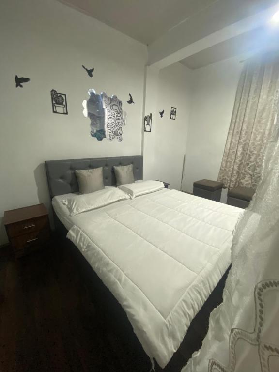 a bedroom with a large bed with white sheets at Noor Lyang in Gangtok