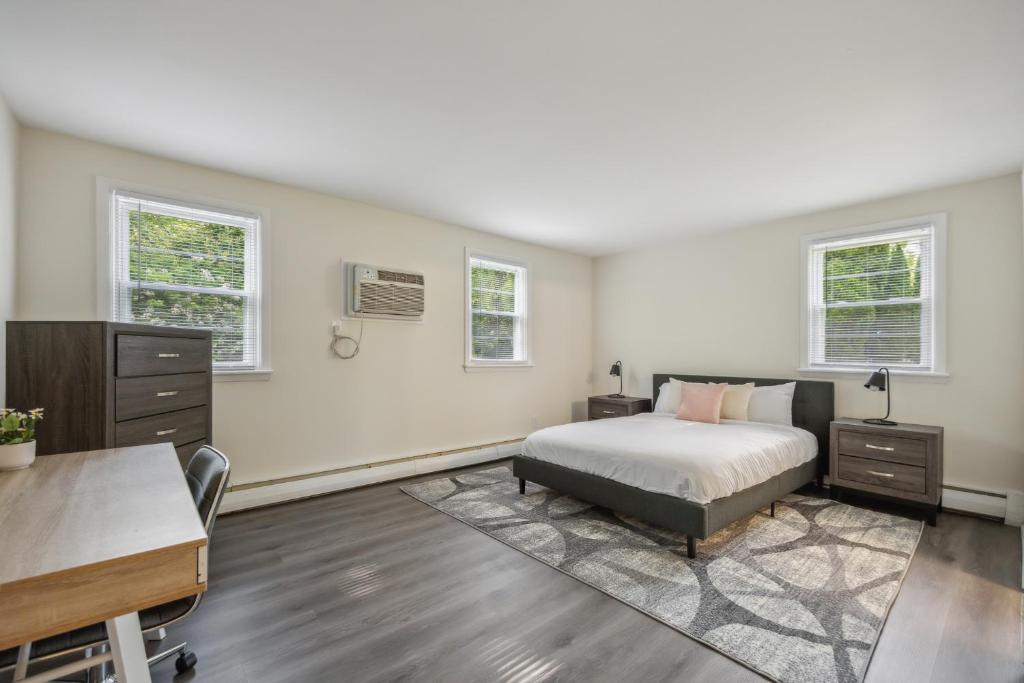 a bedroom with a bed and a desk and two windows at Pine Brook 816 I Corporate 2Br Apartment ! in Newark