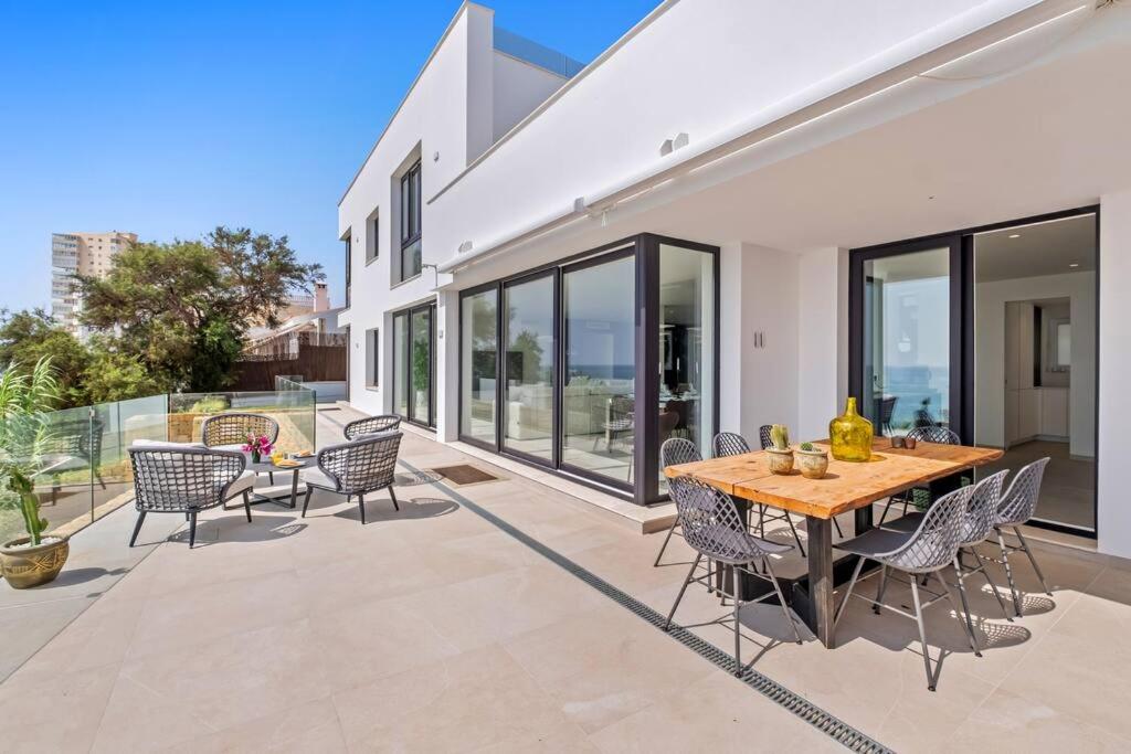 un patio avec une table et des chaises en bois dans l'établissement Villa Kalma - Torreguadiaro - Sotogrande, à Sotogrande
