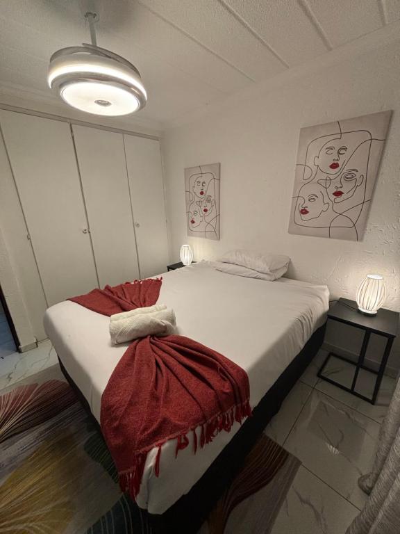 Un dormitorio con una cama grande con una manta roja. en 124 Key West, en Hartbeespoort
