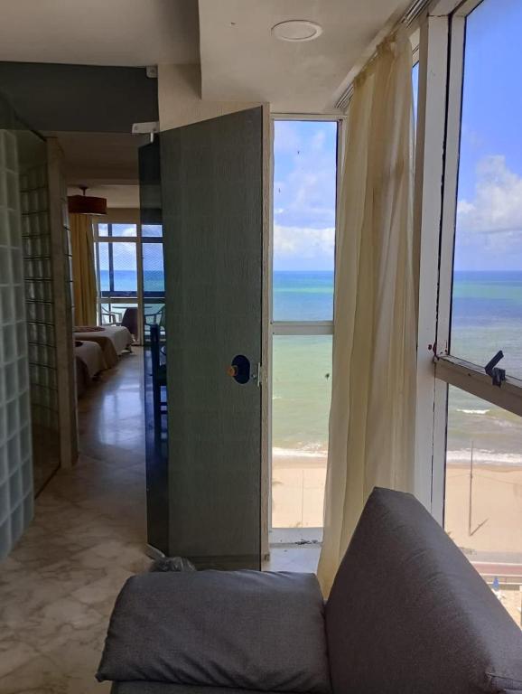 a living room with a view of the beach at Flat Beira Mar in Recife