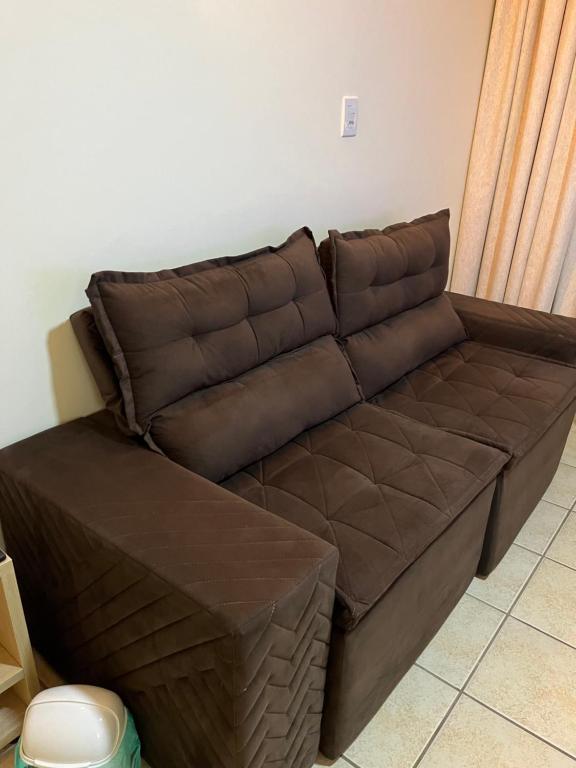 - un canapé en cuir brun dans le salon dans l'établissement Apartamento centro de Peruíbe, à Peruíbe