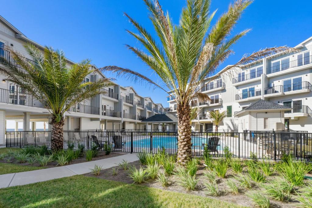 a courtyard with palm trees in front of a building at One More Time Again by Pristine Properties Vacation Rentals in Mexico Beach