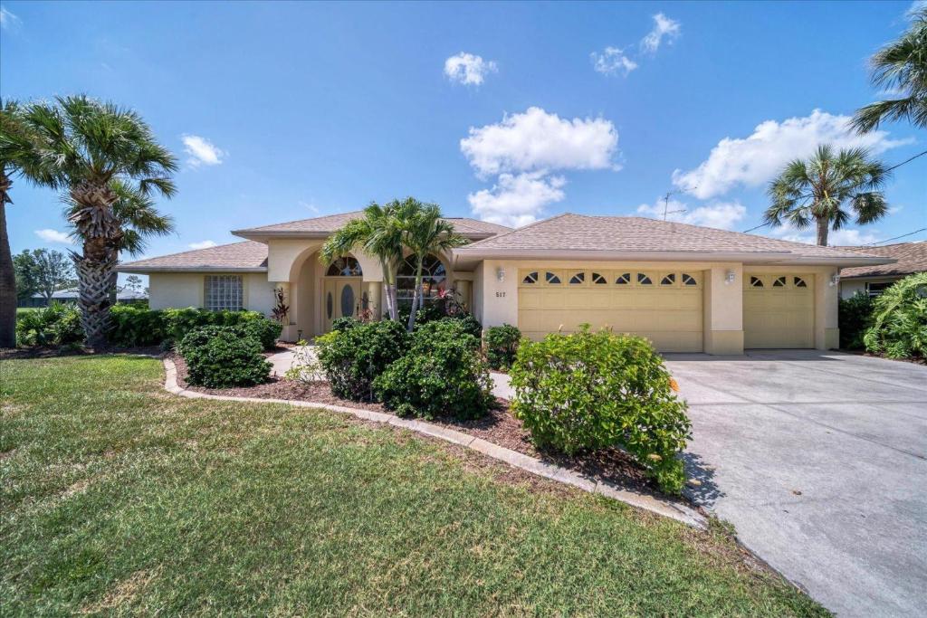 a large house with palm trees and a driveway at Southern Breeze in Rotunda-West