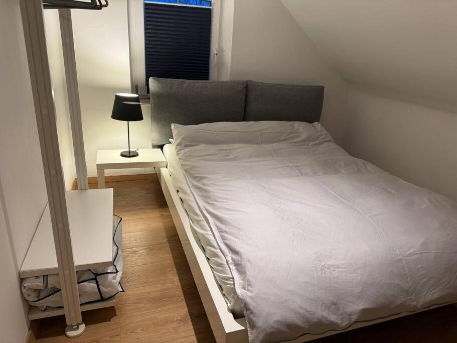 a bed in a small room with a night stand at gemütliche Wohnung, tolle Lage, auch für Messe in Meerbusch