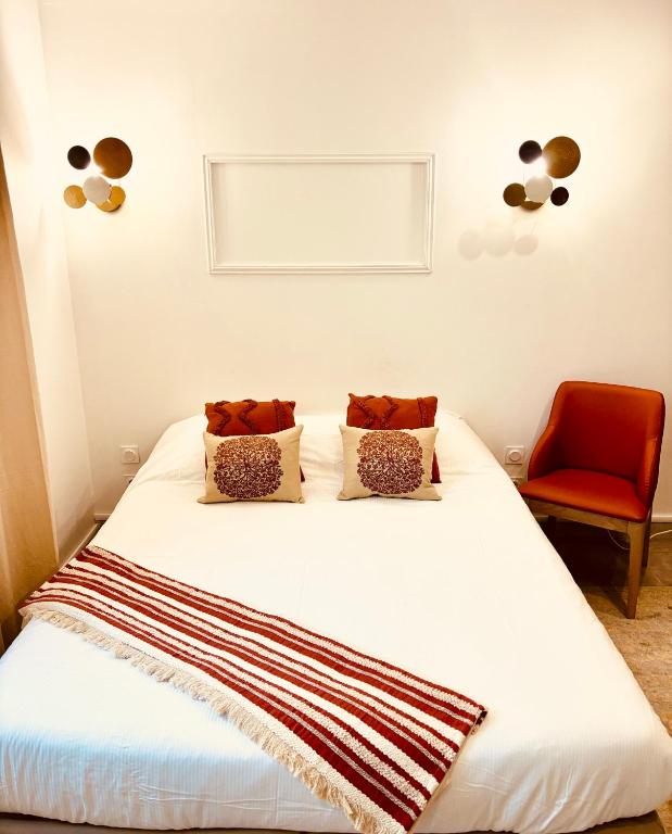 - une chambre avec un lit blanc et une chaise rouge dans l'établissement Le BARABAN, à Lyon