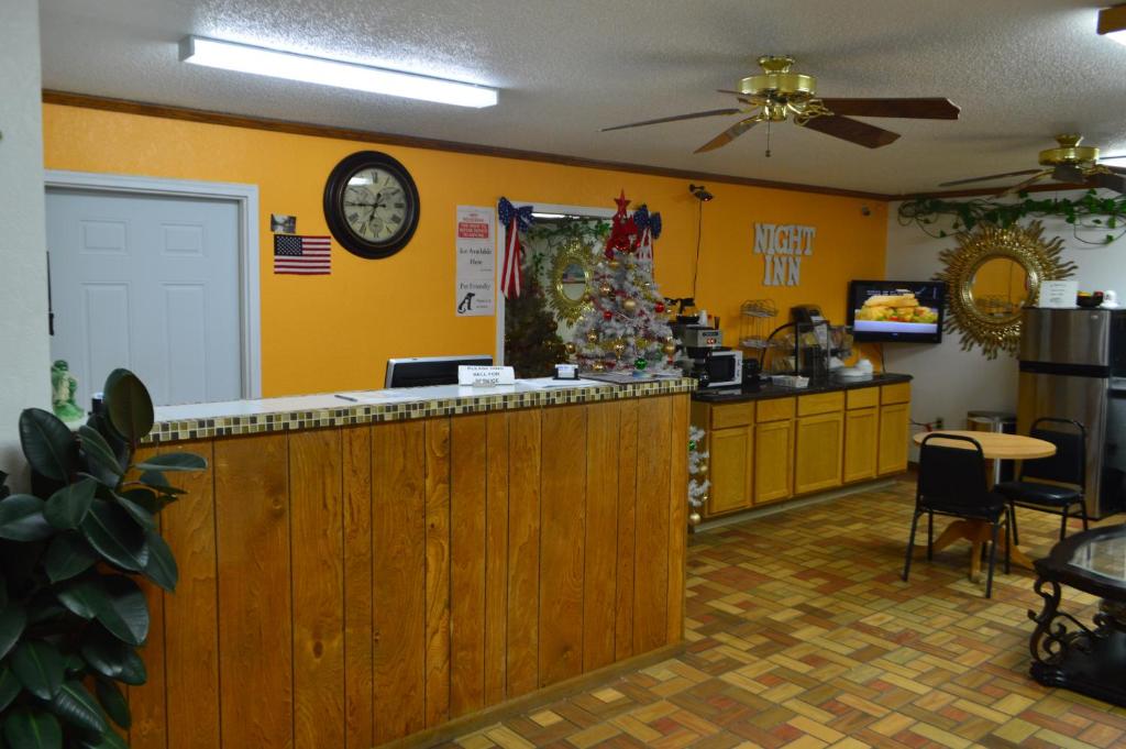 a restaurant with a counter and a clock on the wall at Night Inn in Sweet Springs
