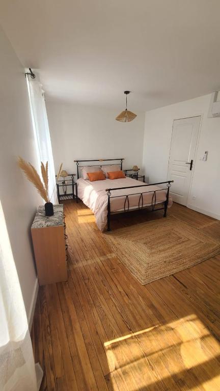 une chambre avec un lit et un parquet dans l'établissement Charmante Maison De Ville, à Barbaste